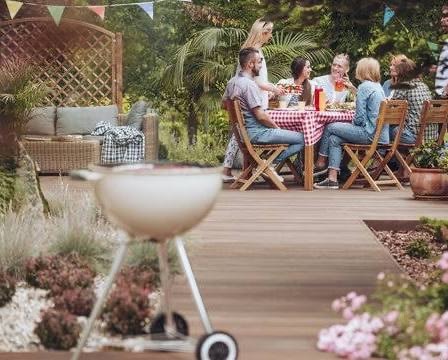 Friends and family gathered around a backyard BBQ